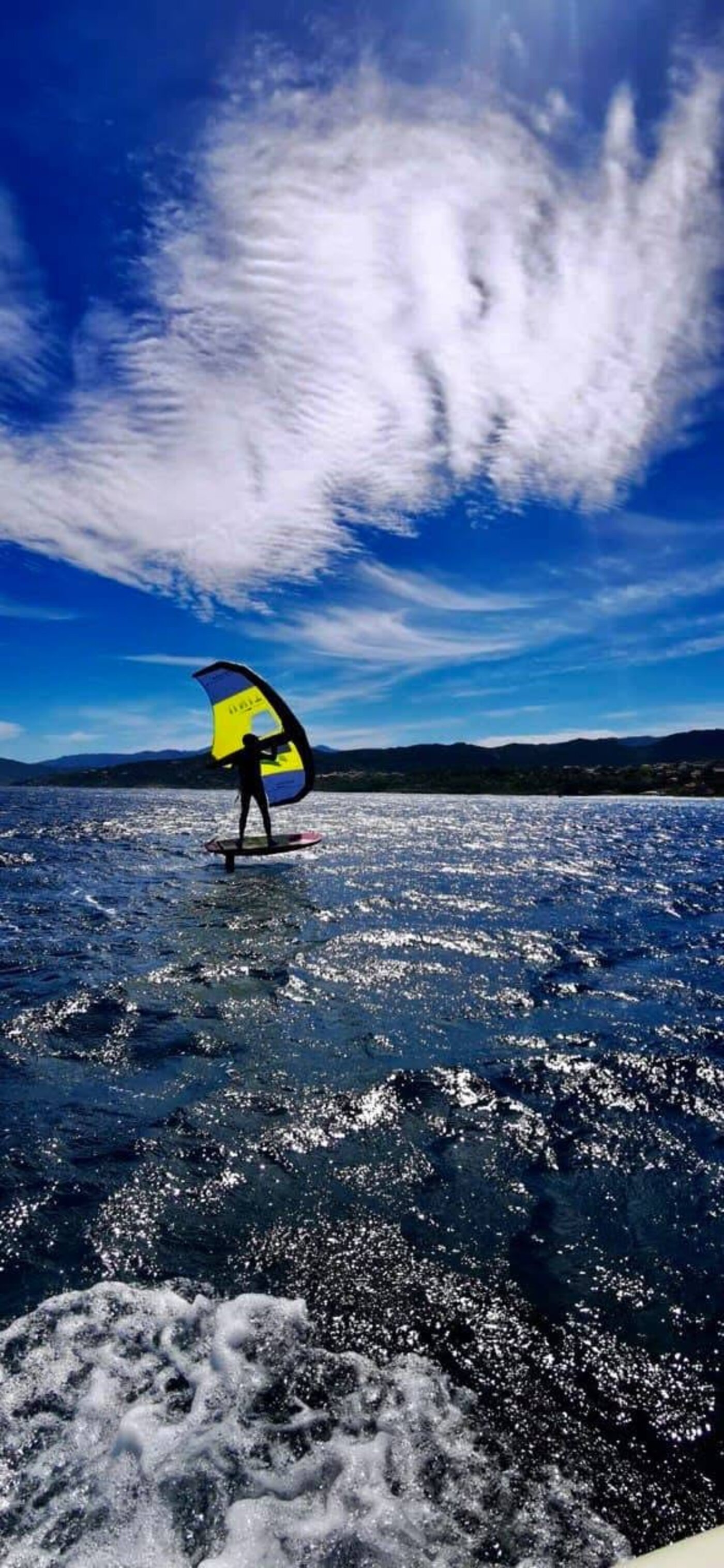 Rider en wingfoil sous un ciel spectaculaire à L'Île-Rousse